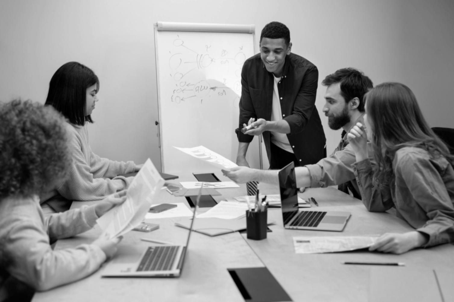 Grupo de personas colaborando en sesión de aprendizaje financiero
